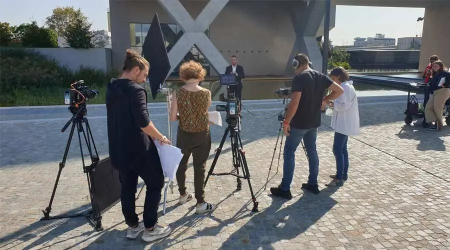 Troupe video al lavoro con cavalletti e monitor su una terrazza