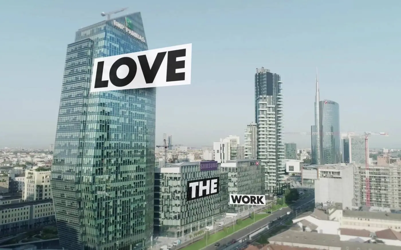 Skyline di Milano con scritte in sovrimpressione su un grattacielo